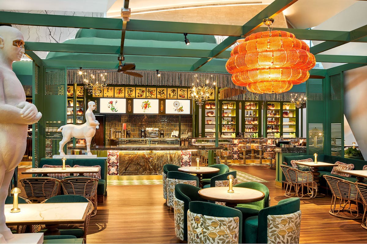 A restaurant interior featuring green chairs and tables
